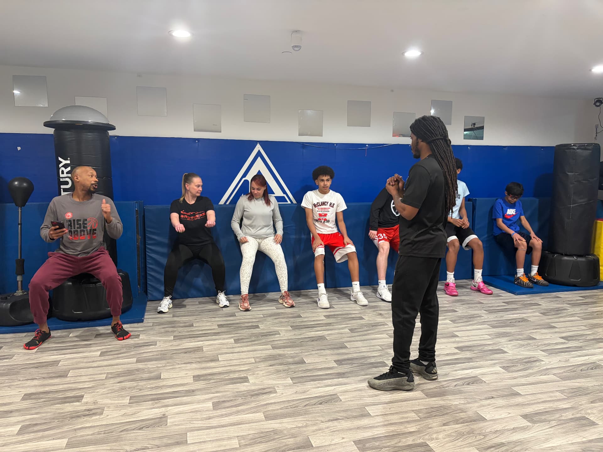 Group holding a wall-supported squat hold