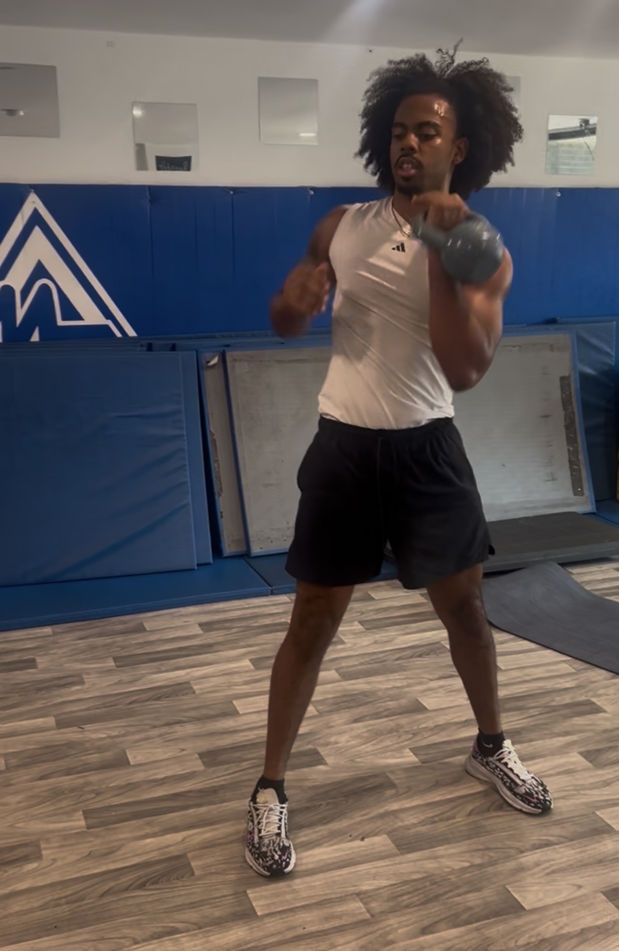 Athlete flowing through a kettlebell clean into rack