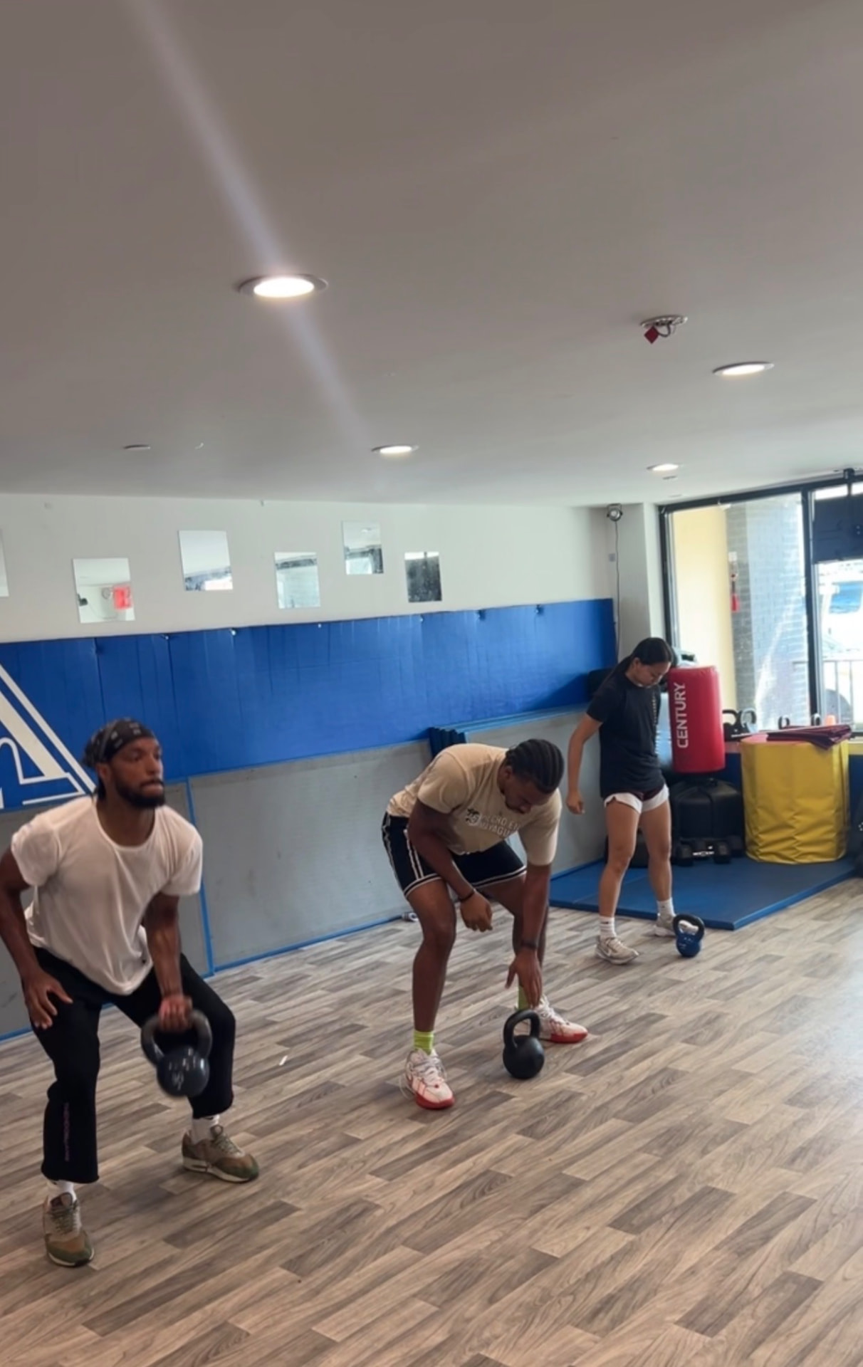 Group flowing through kettlebell sequences in class