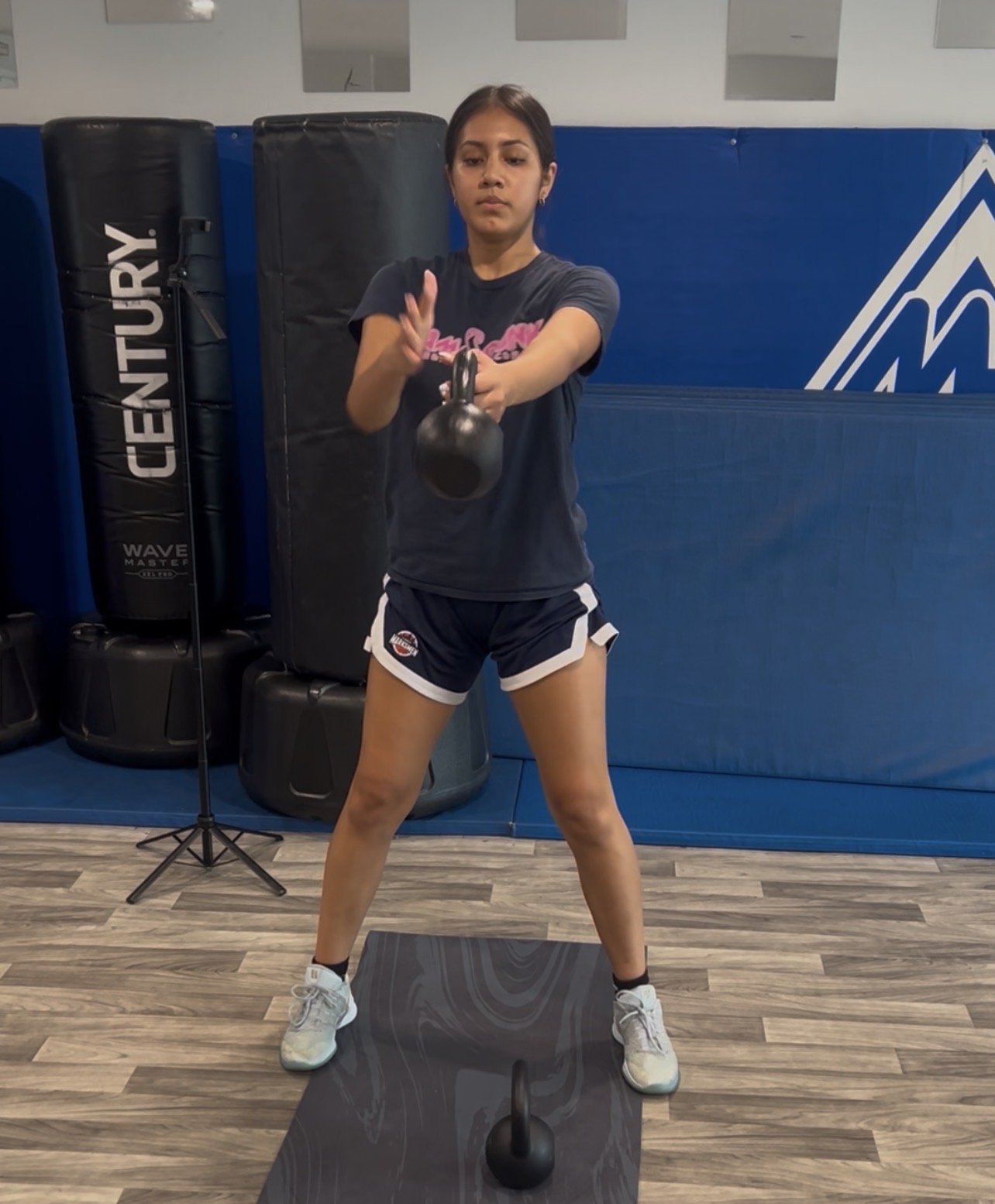 Athlete driving a single-arm kettlebell swing to chest height